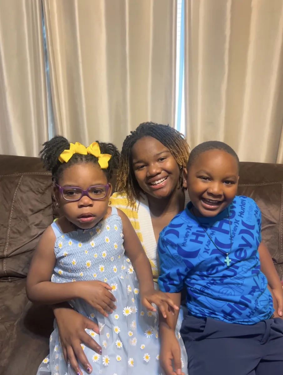 Cupcake sitting on the couch with her big sister Karli and brother Jaxson