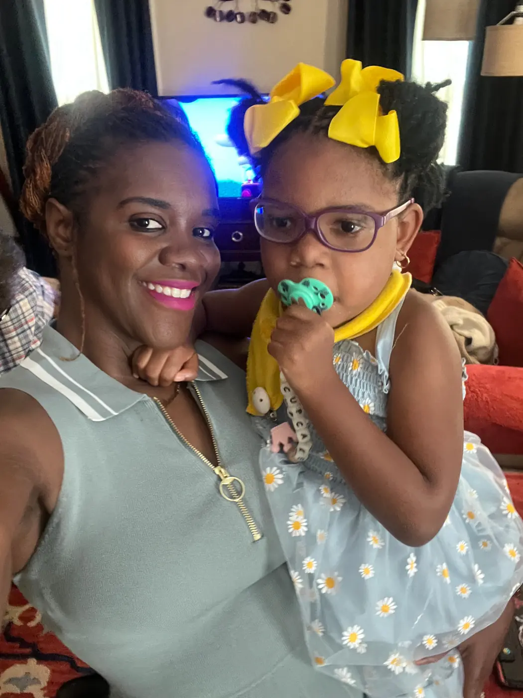 Cupcake with a yellow bow, held by her mom